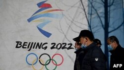 중국 베이징 시내에 있는 2022 동계올림픽 홍보물 앞으로 시민들이 지나가고 있다.