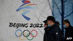 2021年12月1日行人走過北京2022年冬奧會會徽。