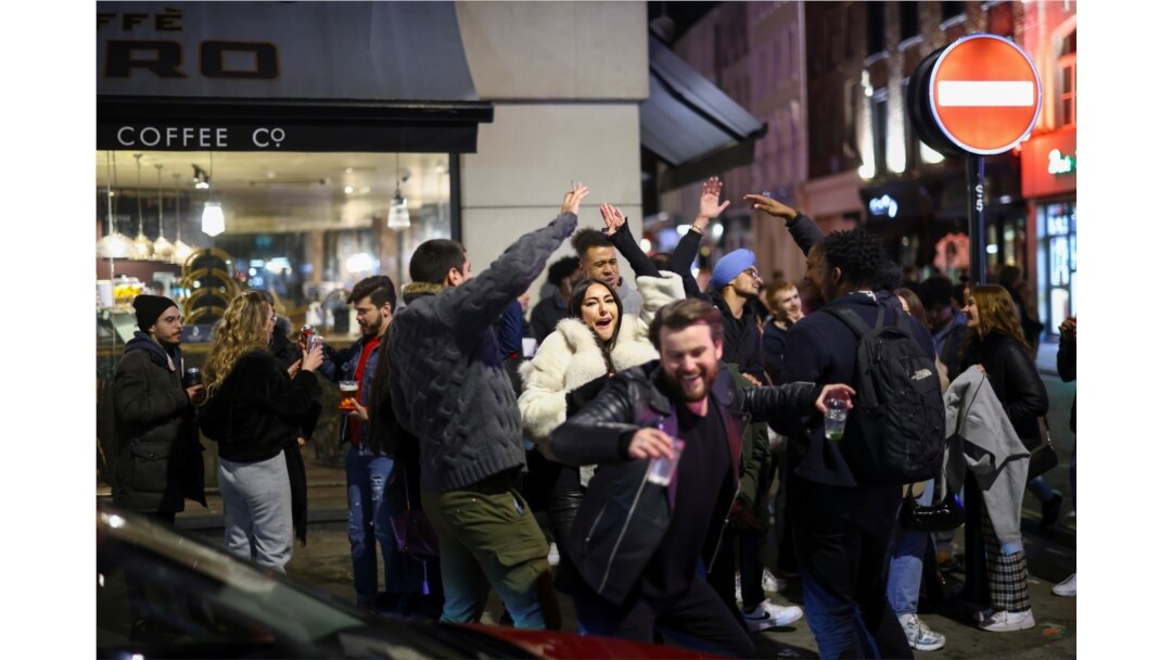 Sekelompok orang menari saat mereka berpesta di sebuah jalan di Soho, saat pemerintah melonggarkan pembatasan wilayah di tengah pandemi COVID-19 di London, Inggris, 12 April 2021.
