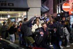 Sekelompok orang menari saat mereka berpesta di sebuah jalan di Soho, saat pemerintah melonggarkan pembatasan wilayah di tengah pandemi COVID-19 di London, Inggris, 12 April 2021.