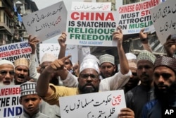FILE - Indian Muslims shout slogans during a protest against the Chinese government, in Mumbai, India, Sept. 14, 2018. Nearly 150 Indian Muslims held a street protest demanding that China stop detaining thousands of Uighur Muslims.