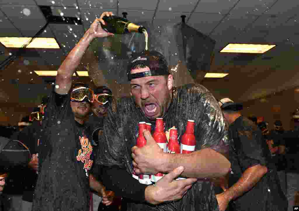 Baltimore Orioles pitcher Tommy Hunter is doused in the visitors&#39; clubhouse after the Orioles defeated the New York Yankees 5-2 in a baseball game to get to the playoffs in New York, Oct. 2, 2016.