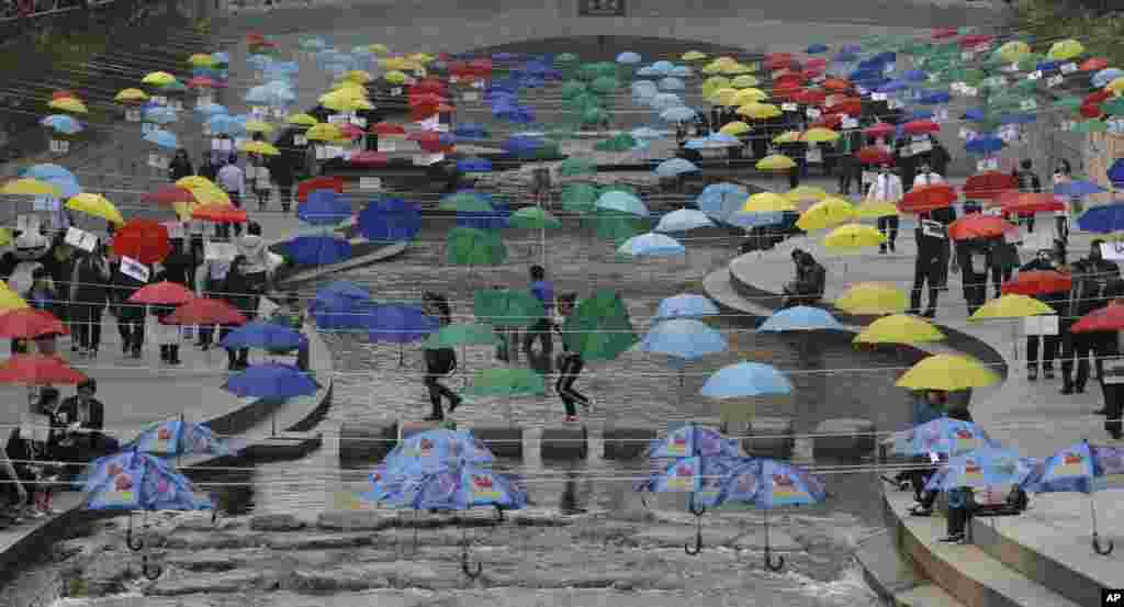 Visitors walk under the umbrellas symbolizing the earth's environment and peace along the Cheonggye stream in Seoul, South Korea.