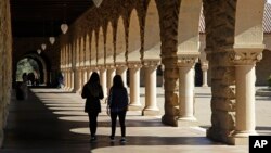 FILE- Students walk on the Stanford University campus in Santa Clara, Calif., March 14, 2019.