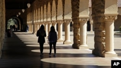 FILE- Students walk on the Stanford University campus in Santa Clara, California, March 14, 2019. 