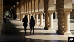 FILE- Students walk on the Stanford University campus in Santa Clara, California, March 14, 2019. 