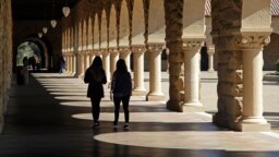 FILE- Students walk on the Stanford University campus in Santa Clara, California, March 14, 2019. 