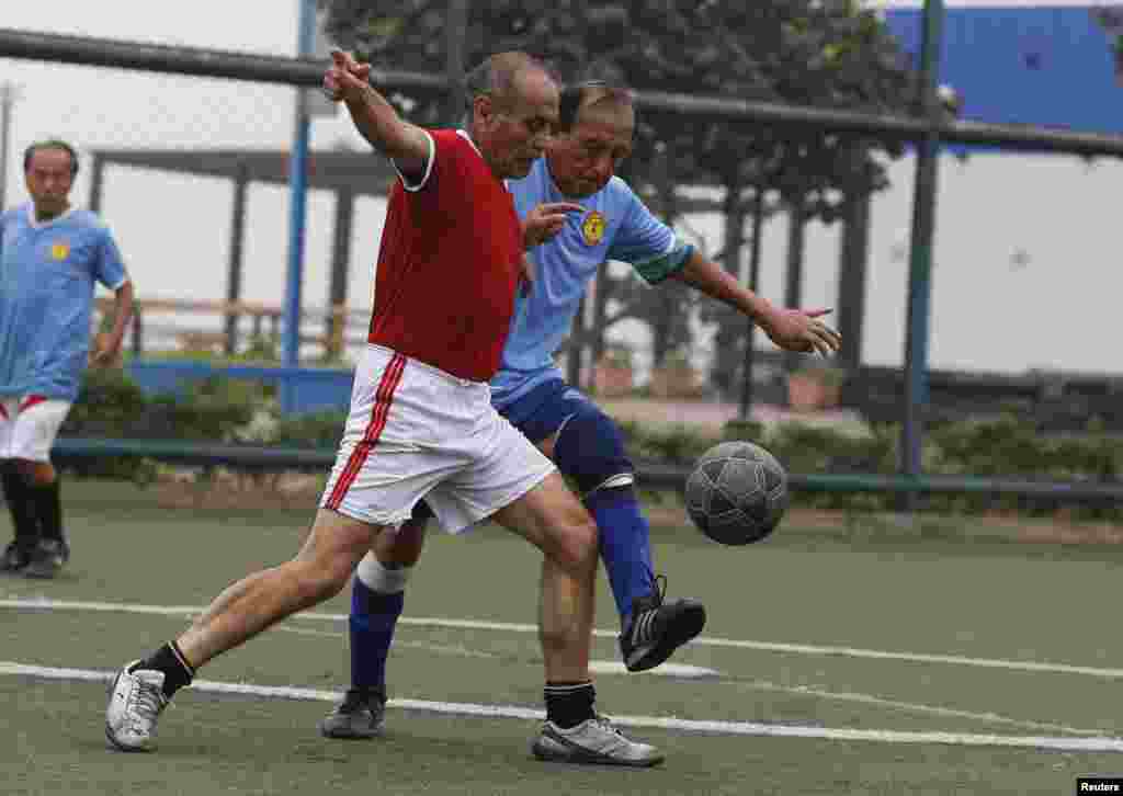 فٹبال کو اپنے اختیار میں رکھنے کے لیے دو حریف کھلاڑی۔