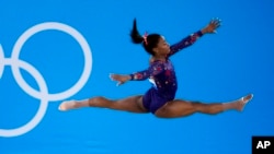 FILE- Simone Biles, of United States, performs her floor exercise routine during the women's artistic gymnastic qualifications at the 2020 Summer Olympics, Sunday, July 25, 2021, in Tokyo. (AP Photo/Ashley Landis)