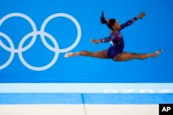 FILE- Simone Biles, of United States, performs her floor exercise routine during the women's artistic gymnastic qualifications at the 2020 Summer Olympics, Sunday, July 25, 2021, in Tokyo. (AP Photo/Ashley Landis)