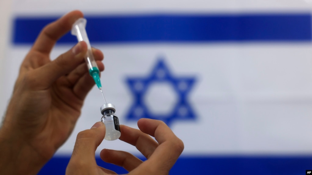 An Israeli military paramedic prepares a Pfizer COVID-19 vaccine, to be administered to elderly people at a medical center in Ashdod, southern Israel, Thursday, Jan. 7, 2021. (AP Photo/Tsafrir Abayov)