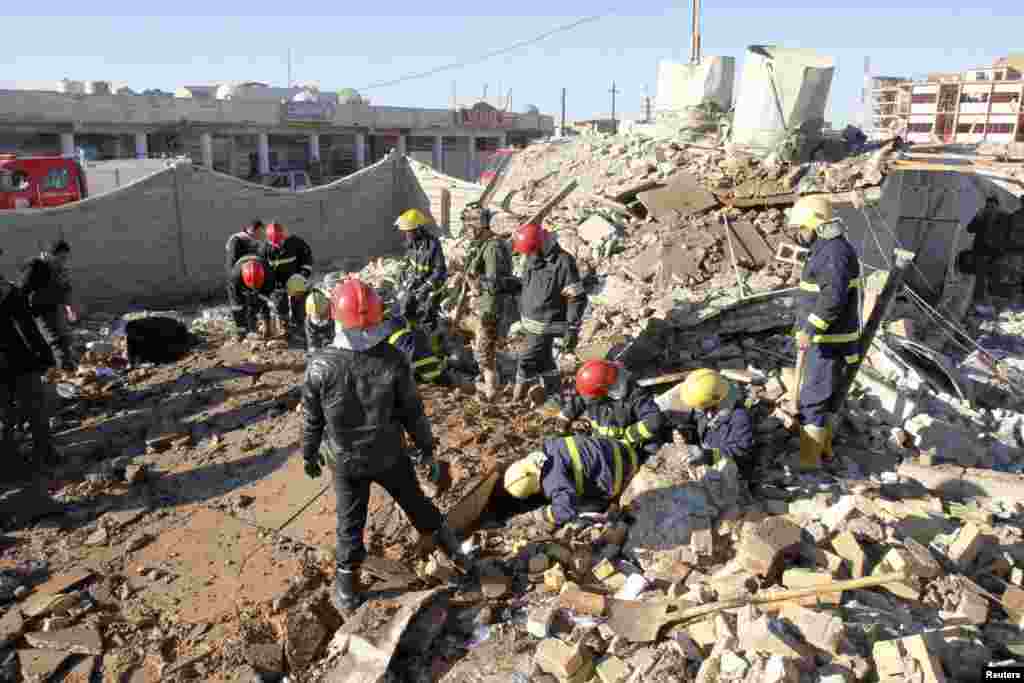 Iraqi civil defense personnel inspect a damaged building after a suicide attack in Kirkuk, Iraq, January 16, 2013. 