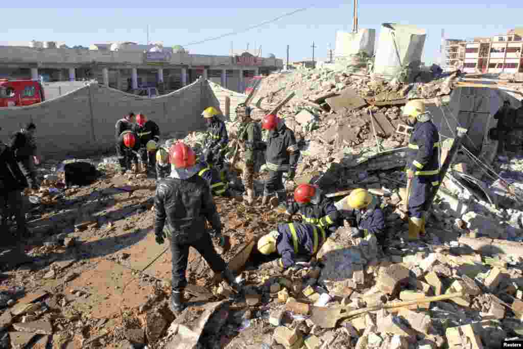 Iraqi civil defense personnel inspect a damaged building after a suicide attack in Kirkuk, Iraq, January 16, 2013.