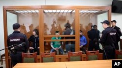 From left: Temirlan Eskerkhanov, Shadid Gubashev, Khamzat Bakhayev, Anzor Gubashev and Zaur Dadayev — defendants suspected of involvement in the killing of opposition leader Boris Nemtsov — stand in a glass enclosure during their trial in a Moscow military district court in Moscow, Russia, June 27, 2017. 