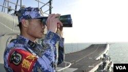 2013年11月26日，中國海軍“遼寧號”航空母艦在南中國海試航期間，一名執勤水兵在甲板上瞭望。