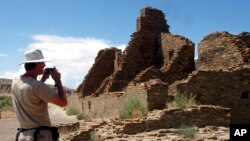 FILE - A tourist takes a picture of Anasazi ruins in Chaco Culture National Historical Park in New Mexico, Aug. 10, 2005.