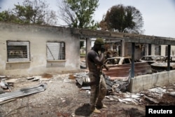 FILE - A soldier walks through the burnt building at the headquarters of Michika local government in Michika town, after the Nigerian military recaptured it from Boko Haram, in Adamawa state, May 10, 2015.