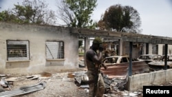 FILE - A soldier walks through the burnt building at the headquarters of Michika local government in Michika town, after the Nigerian military recaptured it from Boko Haram, in Adamawa state, May 10, 2015.