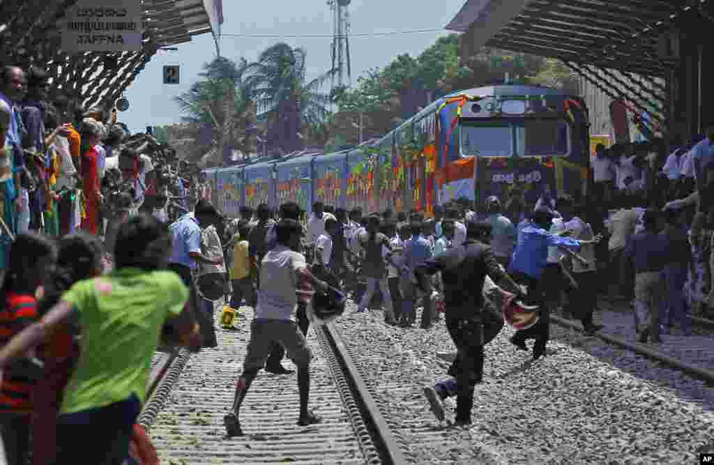 Sri Lankan ethnic Tamils rush towards the train "Queen of Jaffna," after it arrived at Jaffna in Sri Lanka. The once-popular train linking the ethnic Tamil's northern heartland to the rest of the country arrived in Jaffna, 24 years after its suspension due to the civil war. 