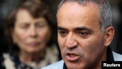 FILE - Former world chess champion and opposition leader Garry Kasparov speaks to the media after walking out of a court building in Moscow, Aug. 24, 2012. 