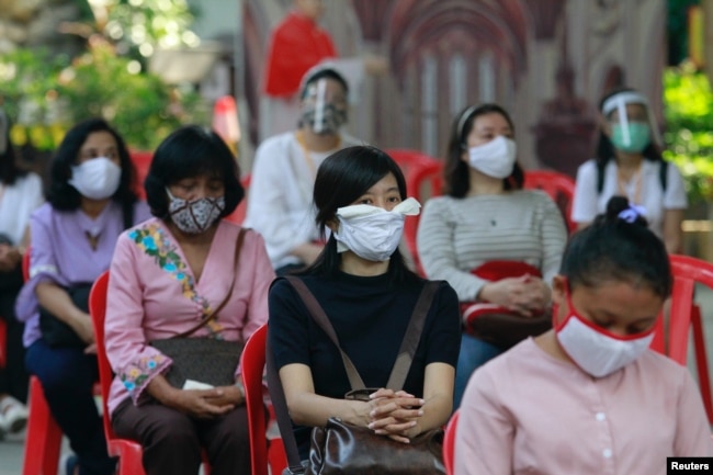Para jemaah mengenakan masker saat menghadiri misa di hari pertama pembukaan gereja setelah pelonggaran pembatasan di tengah pandemi virus corona di Jakarta, 12 Juli 2020. (Foto: Reuters)