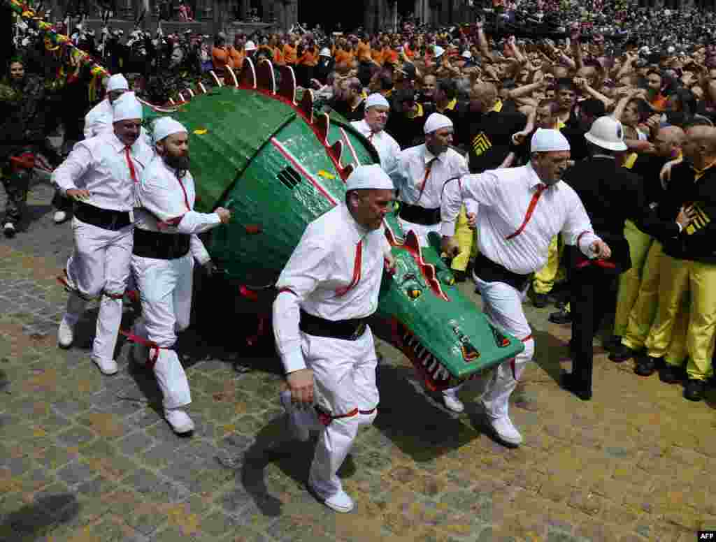 People in costumes take part in a performance showing the fight between a Saint and the dragon at Ducasse, during the Doudou folkloric festival in Mons, Belgium. The Doudou festival includes two parts, a procession at the shrine of Waltrude and a fight between Saint George and the dragon. The Doudou was recognized in 2005 by UNESCO as one of the masterpieces of the Oral and Intangible Heritage of Humanity.