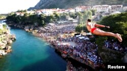 A man "takes a plunge" from the Old Bridge during 450th traditional diving competition in Mostar, Bosnia and Herzegovina, July 31, 2016. 