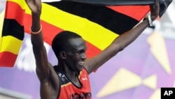 Pelari Uganda Stephen Kiprotich merayakan kemenangan setelah menyelesaikan lomba lari maraton hari Minggu (12/8). 