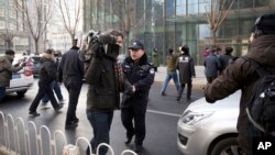 中國政府加大對外國記者的壓制。圖為2014年1月26日，警員阻止在北京的外國記者採訪受審的法律維權人士許志永的辯護律師張慶方。