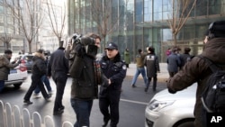 资料照：中国政府加大对外国记者的压制。图为2014年1月26日，警察阻止在北京的外国记者采访受审的法律维权人士许志永的辩护律师张庆方。