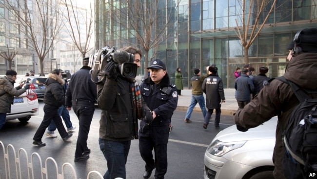 資料照片：2014年1月26日，中國警察阻止在北京的外國記者採訪受審的法律維權人士許志永的辯護律師張慶方。 （美聯社）