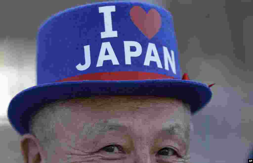 A fan from Japan poses for a picture as he lines up to enter the Maracana Stadium ahead of the opening ceremony for the 2016 Summer Olympics in Rio de Janeiro, Brazil, Aug. 5, 2016.