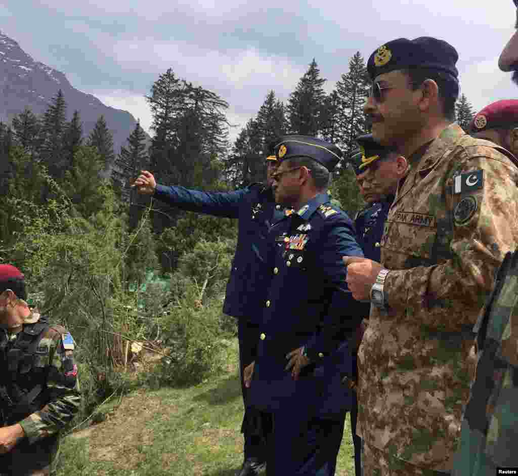 Air Chief Marshal Sohail Aman, center, Chief of the Air Staff, Pakistan Air Force, visits the site of a helicopter crash at Naltar in Gilgit, Pakistan, May 8, 2015.