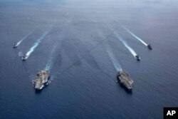 Kapal USS Ronald Reagan (CVN 76) dan USS Nimitz (CVN 68) Carrier Strike Group sedang dalam formasi, di Laut China Selatan, Senin, 6 Juli 2020. (Foto: AP)