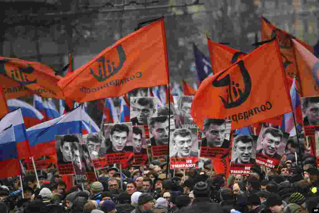 Người tuần hành tưởng nhớ lãnh đạo đối lập Boris Nemtsov mang biểu ngữ xuống đường với hàng chữ &quot;Những viên đạn cho tất cả chúng ta, những anh hùng không bao giờ chết!&quot; tại Moscow, Nga, ngày 1/3/2015.