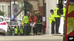 Una mujer arropada con mantas es escoltada por paramédicos cerca del lugar de la explosión en una estación subterránea del metro de Londres. Imagen capturada de un video. Sept. 15, 2017.