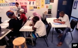 Syrian refugee Ahmad Alabood, right, sits in the back row during English class at Della Lamb Community Services in Kansas City, Mo., on June 13, 2016.