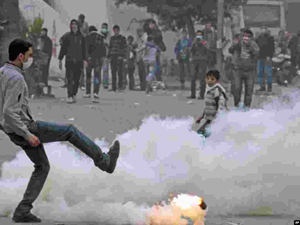 A protester returns a gas canister during clashes with security forces near the Interior Ministry in Cairo, February 6, 2012. (Reuters)
