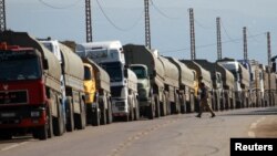 Trucks park at the Lebanese-Syrian border after residents in Lebanon blocked the road to protest what they said were shipments of diesel fuel to the Syrian government February 13, 2013.