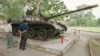 FILE - Tourists in Ho Chi Minh City look at a Soviet-made tank.
