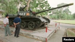 FILE - Tourists in Ho Chi Minh City look at a Soviet-made tank.