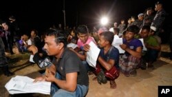 Foreign workers wait for their work documents to be checked by Malaysian immigration officer during an operation to crackdown on illegal immigration on the outskirts of Port Dickson, Negeri Sembilan, Malaysia, July 11, 2017. 