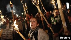 A protester shouts slogans near others holding torches during a demonstration outside the National Palace of Culture, where the political parties in the elections will be holding news conferences, in Sofia, May 12, 2013. 