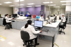 Para ahli kimia bekerja di kantor pusat AstraZeneca, Sydney, Australia, 19 Agustus 2020. (Foto: AAP / Dan Himbrechts via REUTERS)