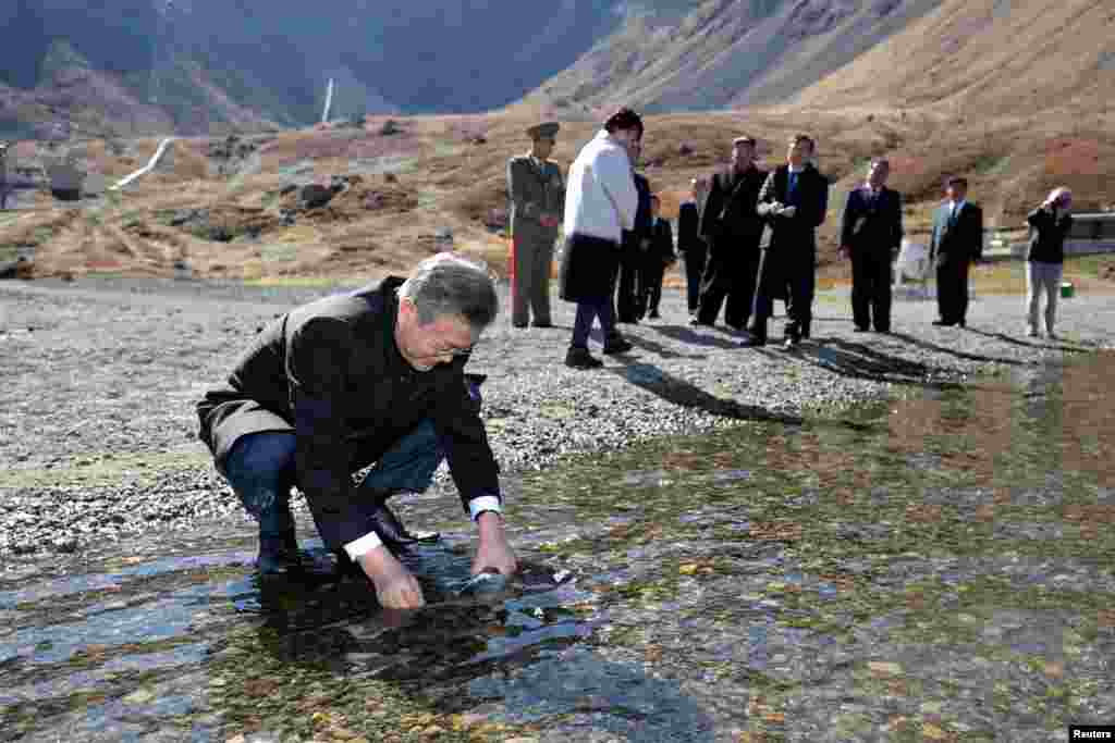 South Korean President Moon Jae-in fills a plastic bottle with water from the Heaven lake of Mt. Paektu, North Korea.