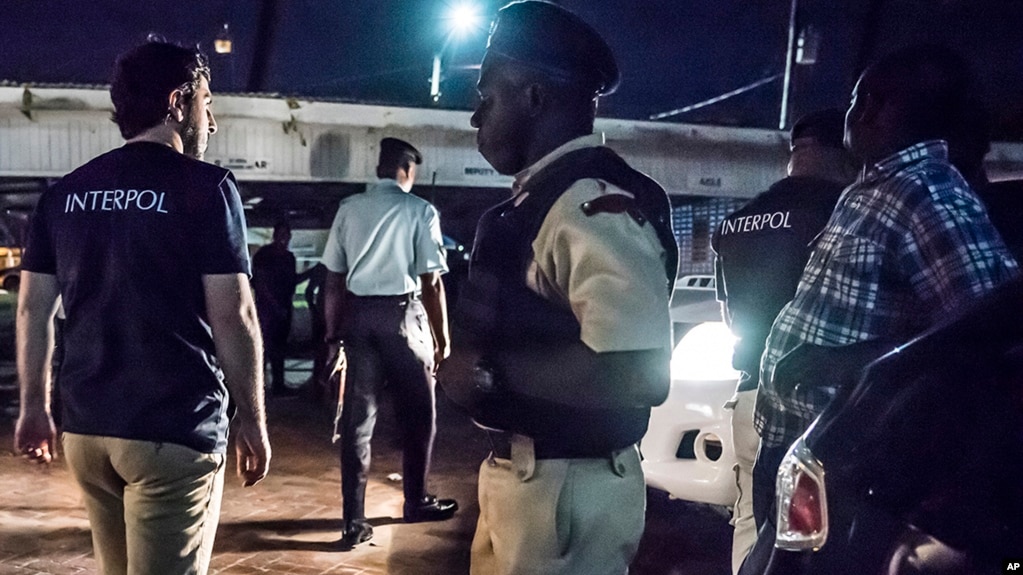 This photo made available by Interpol Monday April 30, 2018 shows Interpol officers during a raid in night clubs in Georgetown, Guyana, on April 7, 2018.