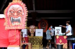 Seorang perempuan memakai masker saat Pilkada di Badung, Provinsi Bali, 9 Desember 2020 di tengah pandemi Covid. (Foto: Antara/Fikri Yusuf via REUTERS)