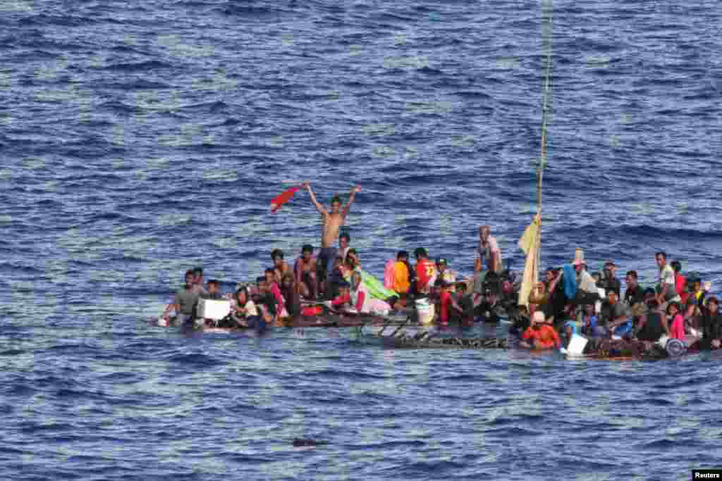 Distressed persons wait to be rescued by sailors and marines aboard the amphibious dock landing ship USS Rushmore in the Pacific Ocean, in the Makassar Strait in Indonesia, June 10, 2015. USS Rushmore rescued 65 people after they were discovered floating on bamboo rafts tied together, with no means of propulsion. (handout photo by the U.S. Marine Corps.)