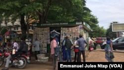 Les lecteurs devant un kiosque à journaux au centre administratif, à Yaoundé, le 30 avril 2020. (VOA/Emmanuel Jules Ntap)