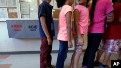 Anak-anak imigran yang ditahan berbaris di kafetaria di Pusat Pemukiman Kabupaten Karnes, rumah sementara bagi wanita dan anak-anak imigran yang ditahan di perbatasan, di Karnes City, Texas, 10 September 2014. (Foto: AP)